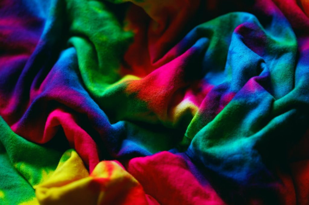 Colorful close-up of crumpled tie-dye fabric showcasing vibrant hues and dynamic patterns.